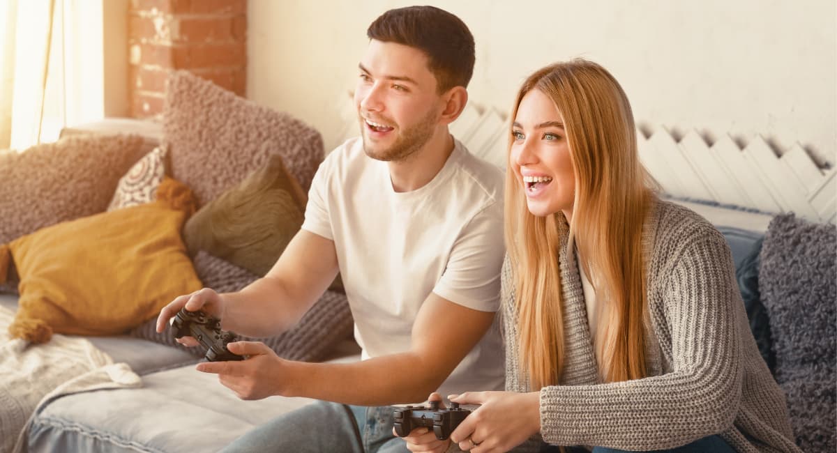 Couple Sitting on Couch Playing Video Game - Date Ideas Canada